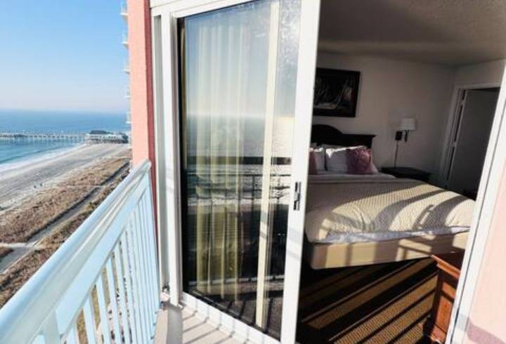 Beachfront hotel room with ocean view balcony.