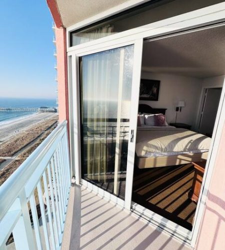 Beachfront hotel room with ocean view balcony.