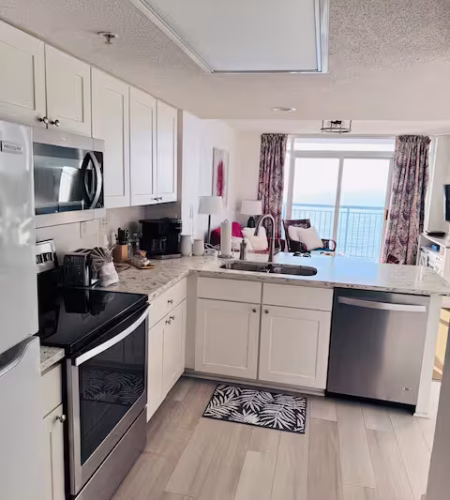 Modern kitchen with ocean view and appliances.