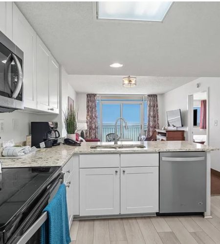 Modern kitchen with ocean view and appliances.