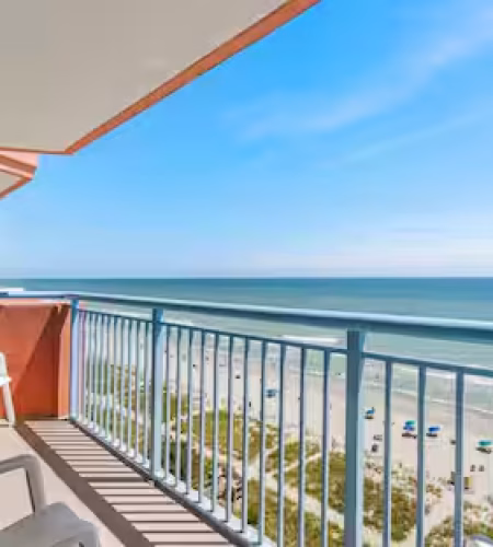 Balcony overlooking beach with ocean view.