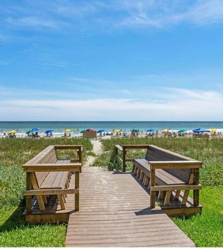 Wooden path leading to a sunny beach.