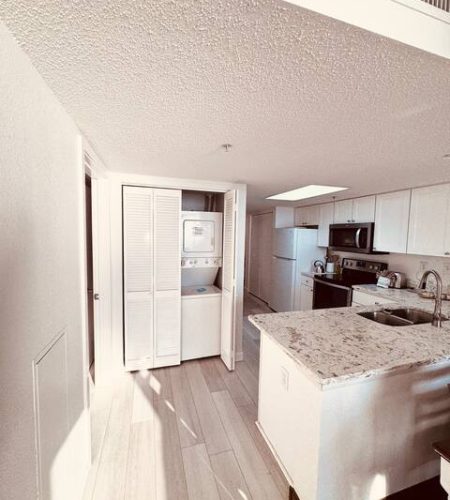 Modern kitchen with appliances and laundry area.